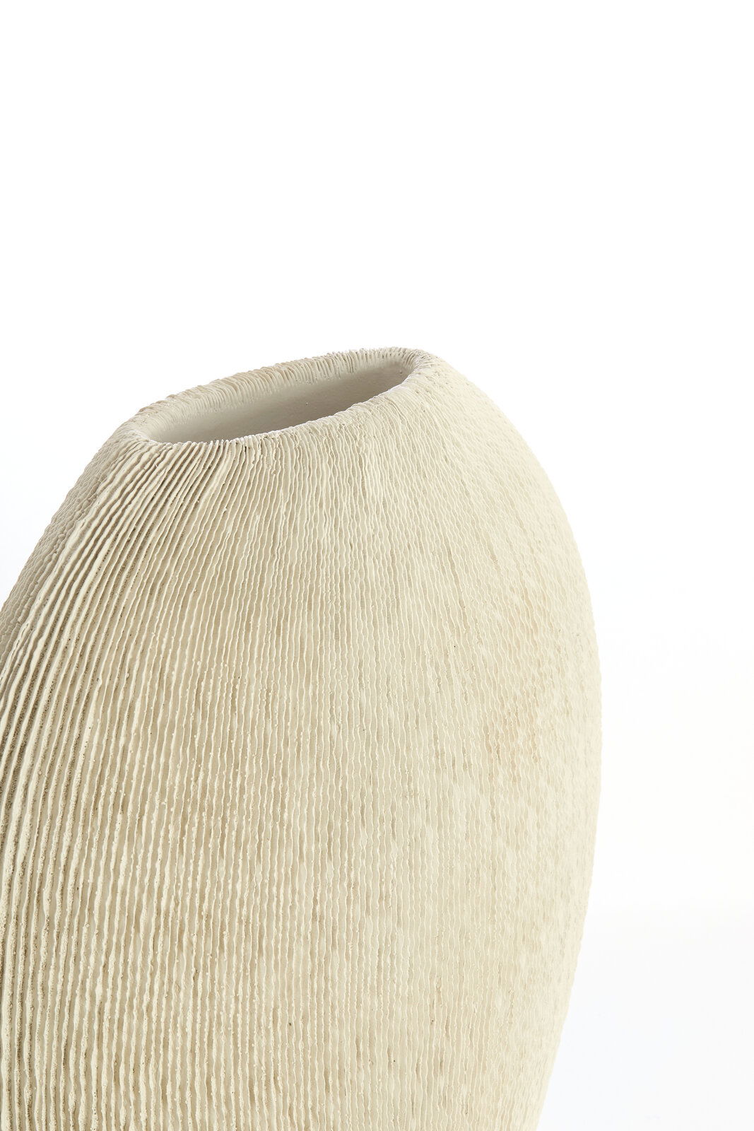 Nahaufnahme einer cremefarbenen Vase mit geriffelter Textur, seitliche Perspektive