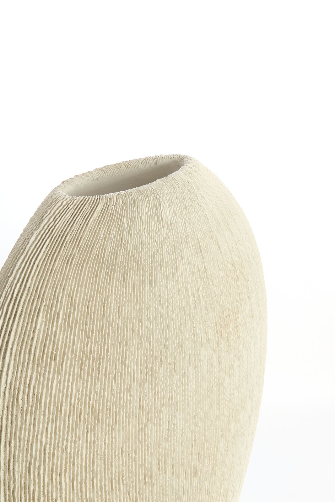 Nahaufnahme einer cremefarbenen Vase mit geriffelter Textur, seitliche Perspektive