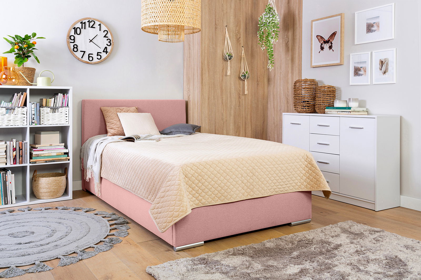 Boxbett 120 in einem gemütlichen Schlafzimmer mit rosa Polsterung, beige Steppdecke und moderner Dekoration, seitliche Perspektive