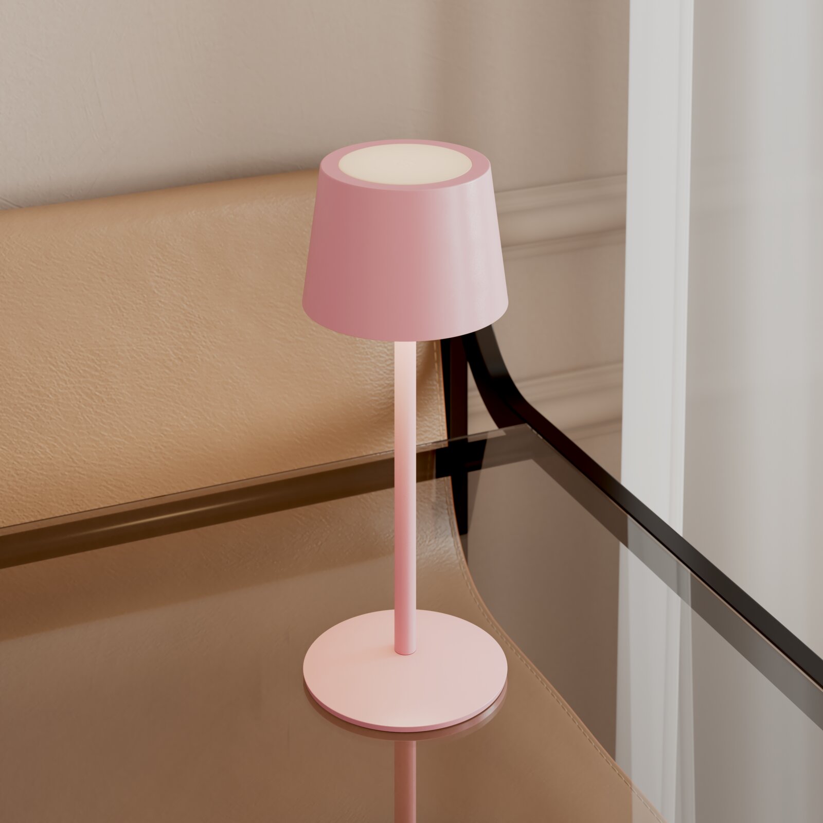 Rosa, minimalistische Tischleuchte mit zylindrischem Schirm und rundem Fuß auf einem Glastisch neben einer beigefarbenen Sitzbank, fotografiert aus leicht erhöhter schräger Seitenperspektive.