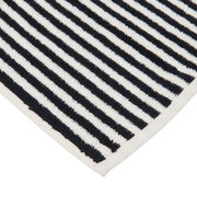 Nahaufnahme einer gestreiften Badematte in Schwarz und Weiß, diagonale Perspektive
