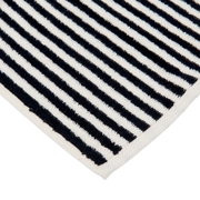 Nahaufnahme einer gestreiften Badematte in Schwarz und Weiß, diagonale Perspektive