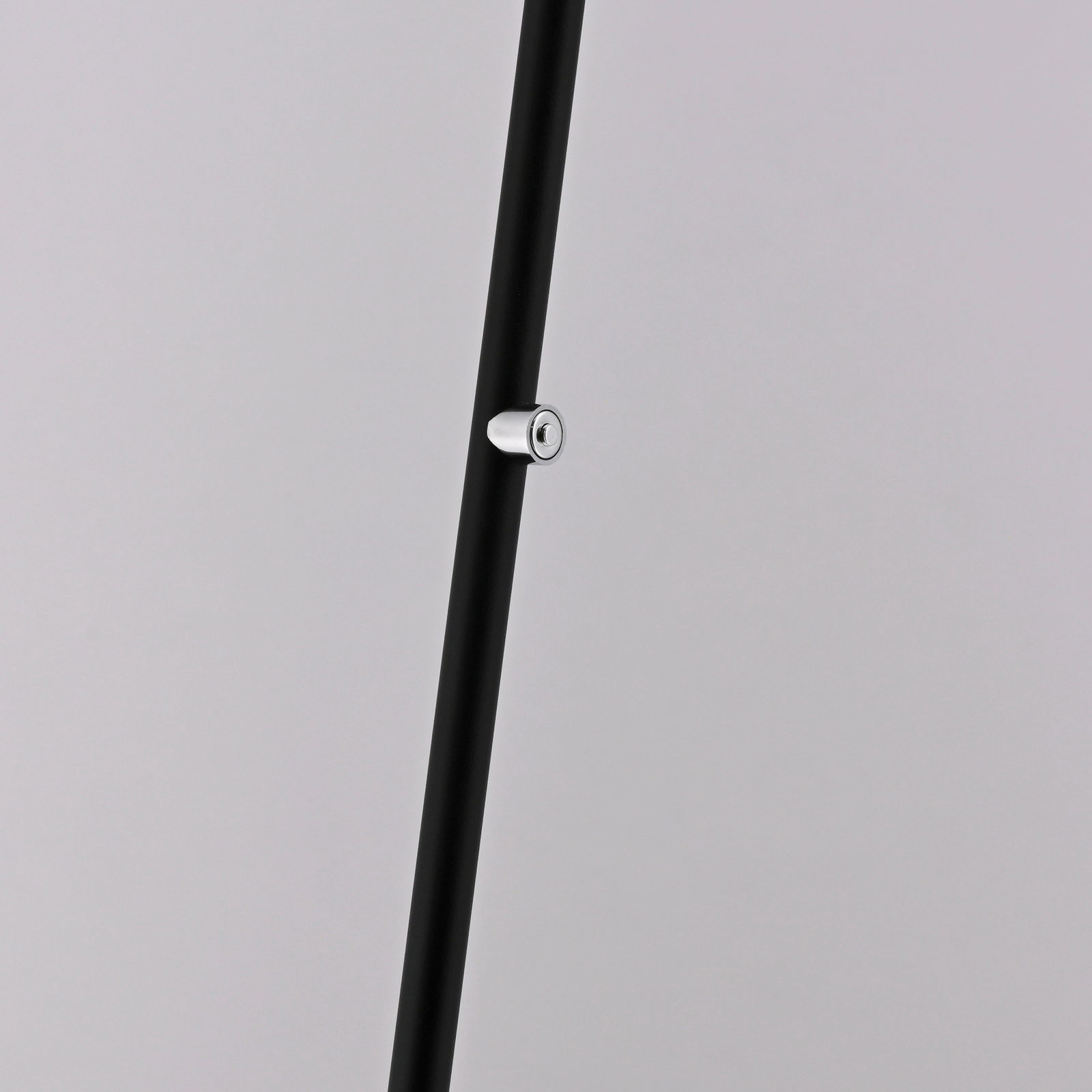 Nahaufnahme eines schwarzen Stabs mit silbernem Knopf, Teil einer Akku-Stehleuchte, seitliche Perspektive