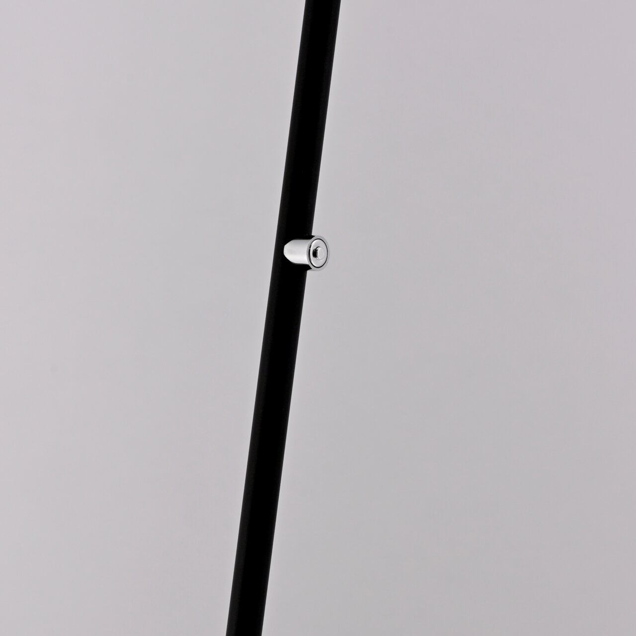 Nahaufnahme eines schwarzen Stabs mit silbernem Knopf, Teil einer Akku-Stehleuchte, seitliche Perspektive