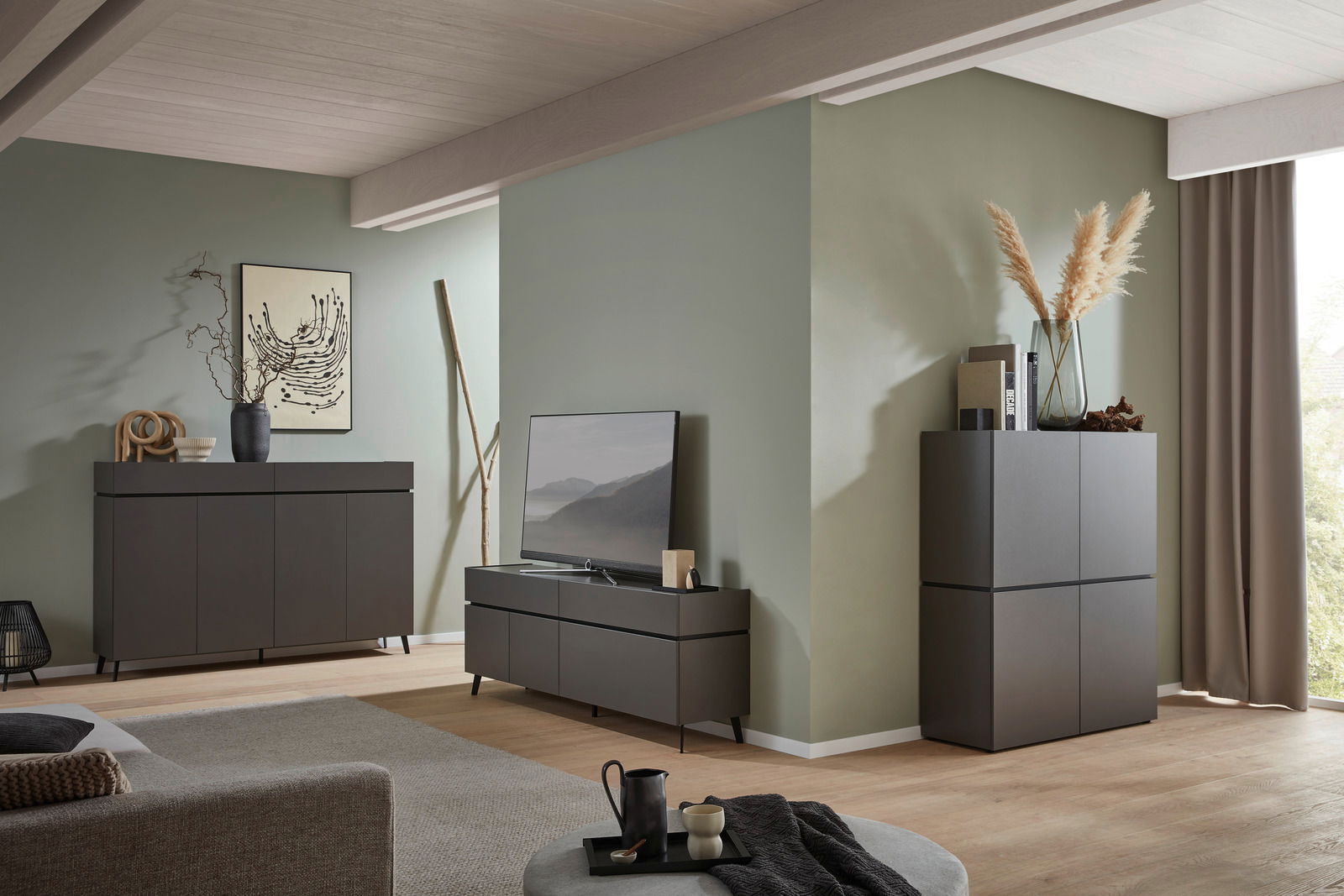 Voleo Tv-kast UNIQUE Modernes Wohnzimmer mit einem dunklen Sideboard, einem TV-Lowboard und einem hohen Schrank, dekoriert mit Vasen und Kunstwerken, seitliche Perspektive.