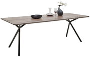 Moderner Esstisch mit Holzplatte und schwarzen Metallbeinen, dekoriert mit einer Vase, einem Weinglas und einer Schale, seitliche Perspektive.