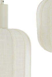 Nahaufnahme einer Hängeleuchte mit cremefarbenem Stoffschirm aus seitlicher Perspektive.