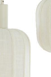 Nahaufnahme einer Hängeleuchte mit cremefarbenem Stoffschirm aus seitlicher Perspektive.