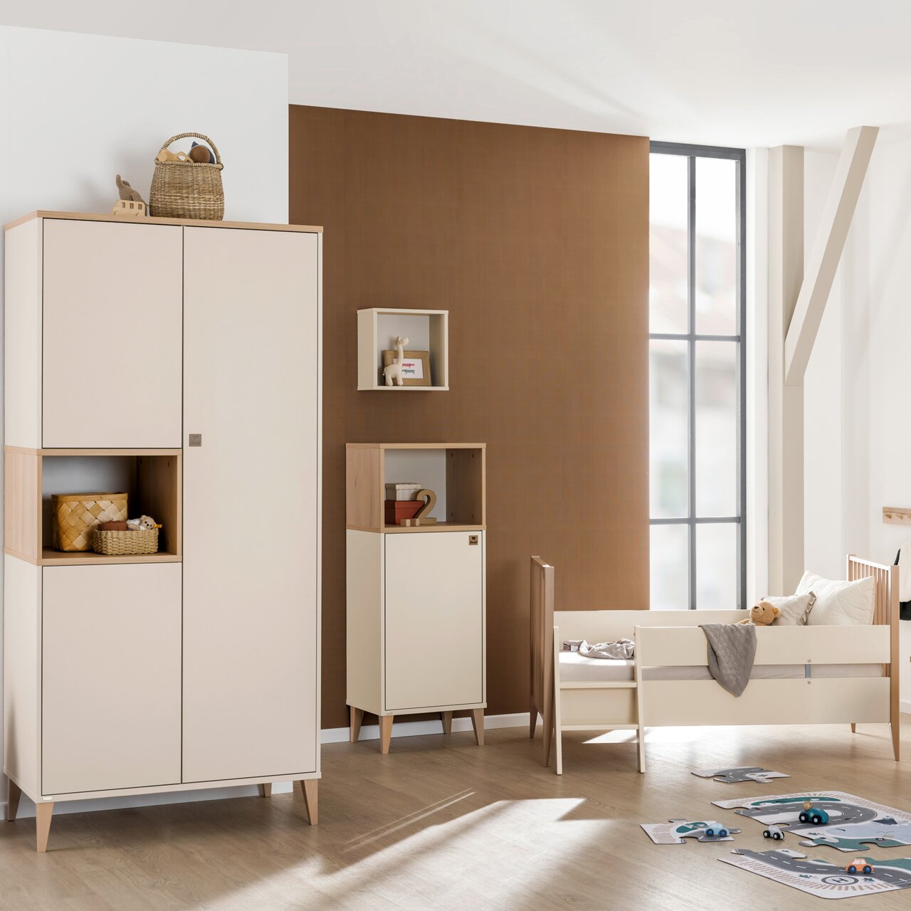 Paidi Kleiderschrank 3-türig MILA&BEN Moderner dreitüriger Kleiderschrank in einem Kinderzimmer, frontal fotografiert, mit hellem Holz und weißen Türen, umgeben von weiteren Möbeln und Spielzeug.