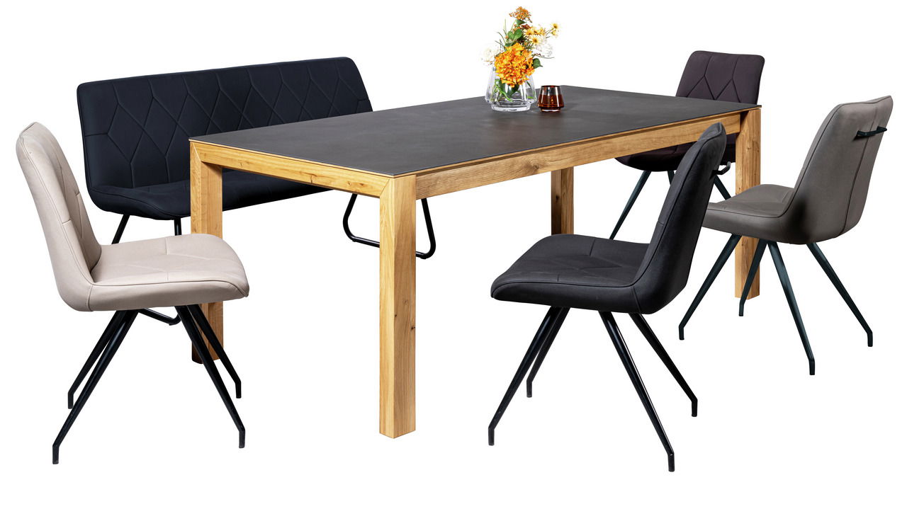 Moderner Esstisch 140x90cm mit Holzbeinen und dunkler Tischplatte, umgeben von stilvollen Stühlen und einer Bank, seitliche Perspektive.