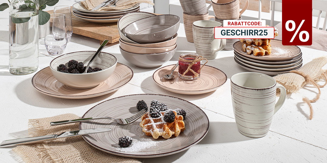 Rustikales Geschirrset mit Tellern, Schalen und Tassen, serviert mit Waffeln und Brombeeren auf hellem Tisch