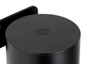 Nahaufnahme einer schwarzen, zylindrischen Akku-Wandleuchte mit einem dezenten Logo auf der Oberseite.