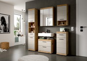 Modernes Badezimmermöbel-Set in Holzoptik und Weiß mit Spiegelschrank, Waschtisch und Hochschränken an grauer Wand, frontal aus leicht schräger Perspektive aufgenommen.