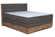Boxspringbett Moderano EMMA in seitlicher Perspektive, mit grauem Polster und Holzunterbau.