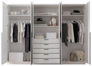 Drehtürenschrank 6-türig in weiß, geöffnet, mit Kleidung, Regalen und Schubladen, frontal fotografiert.