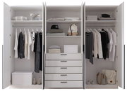 Drehtürenschrank 6-türig in weiß, geöffnet, mit Kleidung, Regalen und Schubladen, frontal fotografiert.