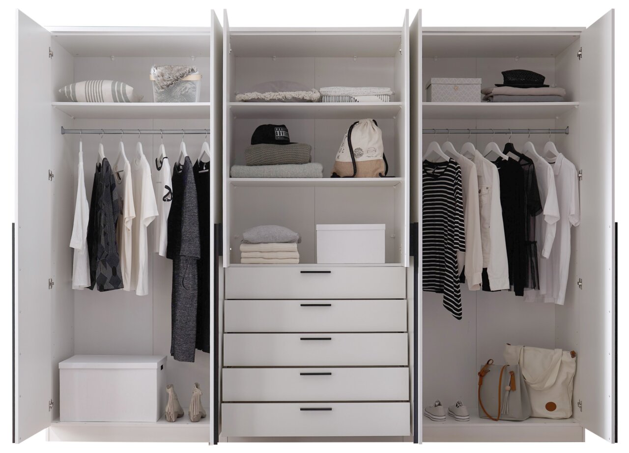 Drehtürenschrank 6-türig in weiß, geöffnet, mit Kleidung, Regalen und Schubladen, frontal fotografiert.