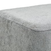 Nahaufnahme eines grauen Hockers mit texturierter Oberfläche, Perspektive von oben.