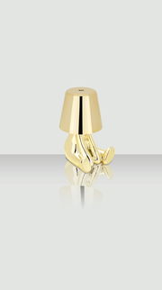 Goldene Akku-Tischleuchte in Form einer sitzenden Figur, seitliche Perspektive