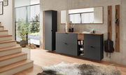 Garderoben-Set in Graphit mit modernem Design, bestehend aus einem hohen Schrank, einer Kommode mit Schubladen und offenen Fächern, einem großen Spiegel und Wandpaneelen mit Haken. Perspektive: Frontalansicht in einem hellen, modernen Flur.
