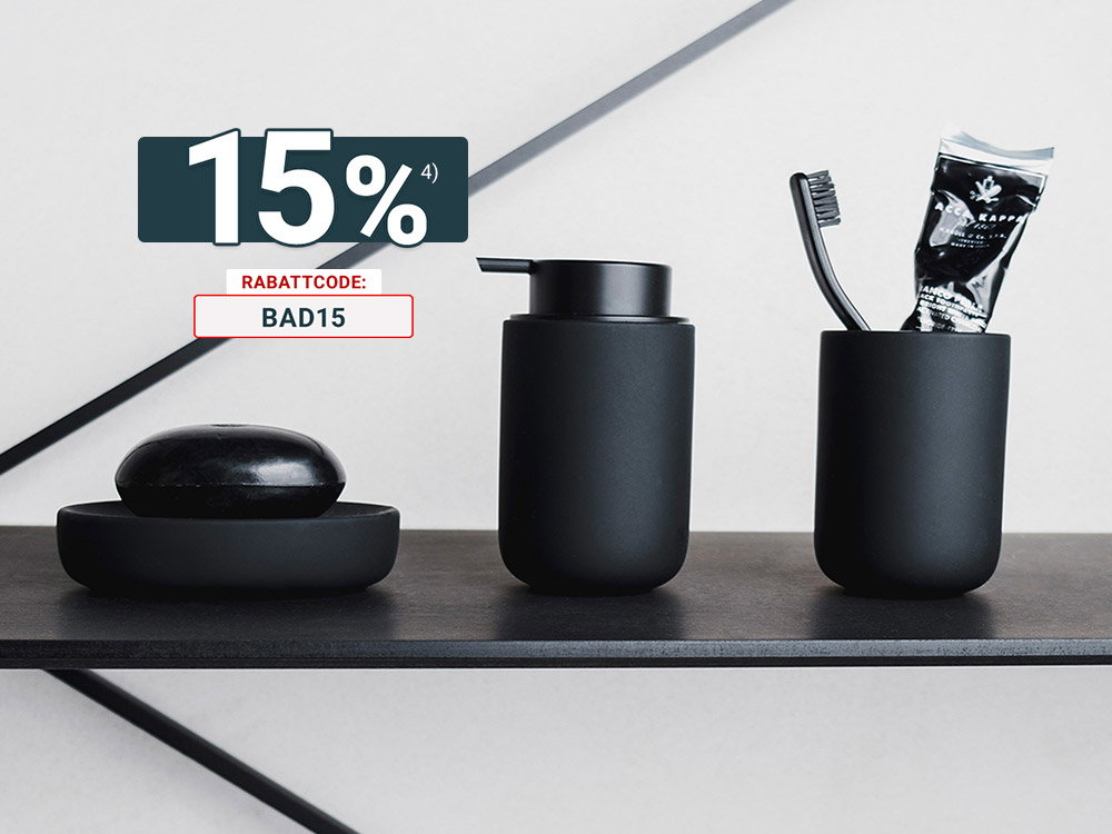 Stilvolle Badezimmeraccessoires in Schwarz: Seifenspender, Zahnputzbecher und Seifenschale auf Ablage