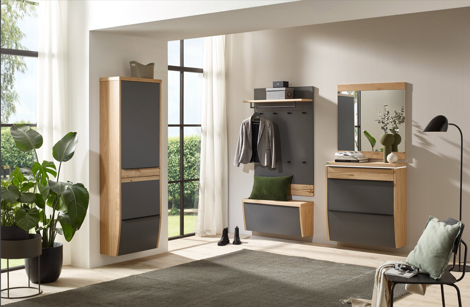 Modernes Garderoben-Set im Flur mit Holzrahmen und anthrazitfarbenen Fronten: hoher Schrank, Wandgarderobe mit Haken und Ablage, Sitzbank/Schuhklappe sowie Kommode mit Spiegel, frontal aus leicht schräger Perspektive aufgenommen.