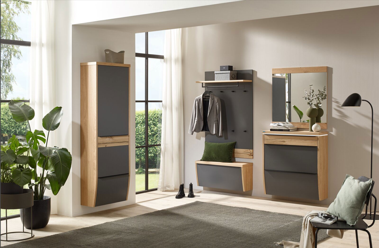 Modernes Garderoben-Set im Flur mit Holzrahmen und anthrazitfarbenen Fronten: hoher Schrank, Wandgarderobe mit Haken und Ablage, Sitzbank/Schuhklappe sowie Kommode mit Spiegel, frontal aus leicht schräger Perspektive aufgenommen.