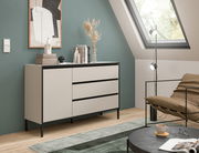 Modernes Sideboard in einem stilvollen Raum mit schrägem Dachfenster, dekoriert mit Kunstobjekten und Büchern, seitliche Perspektive.