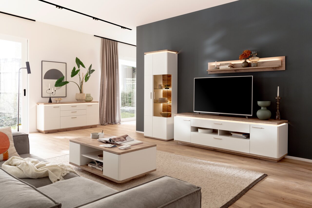 Moderne woonkamermeubels met wandplank, dressoir en hoogkast in een lichte houtlook, gezien vanaf de zijkant.