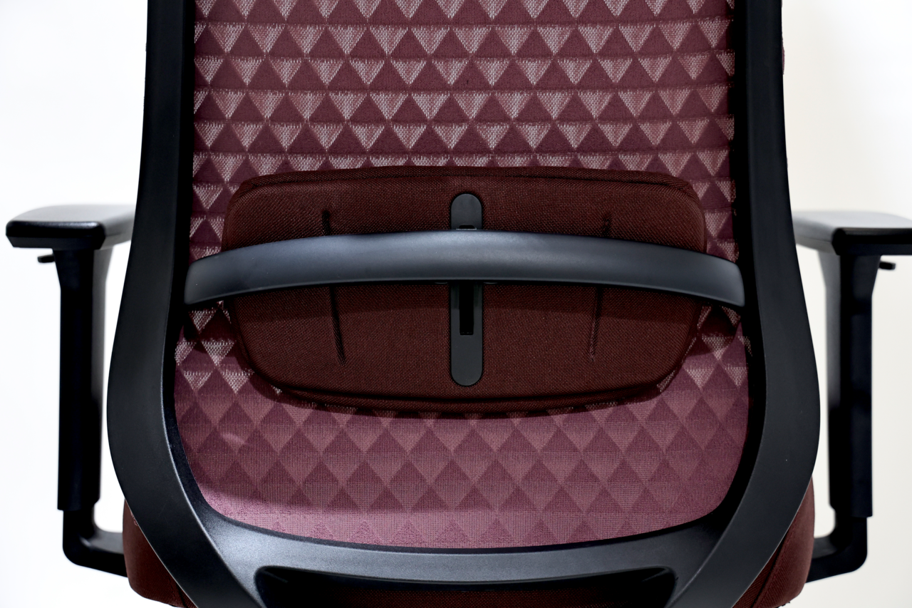 Rückansicht eines Drehstuhls mit geometrischem Muster auf der Rückenlehne und verstellbarer Lendenstütze.
