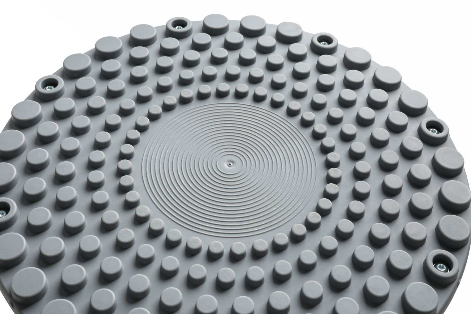 Nahaufnahme der Oberseite eines grauen Schwinghockers mit kreisförmigen Erhebungen und Schraubenlöchern, von oben betrachtet.