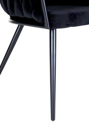 Nahaufnahme eines schwarzen Sessels mit Metallbeinen, seitliche Perspektive