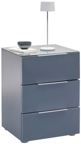 Moderne Nachtkonsole in Grau mit drei Schubladen, darauf eine weiße Tischlampe und Bücher, seitliche Perspektive