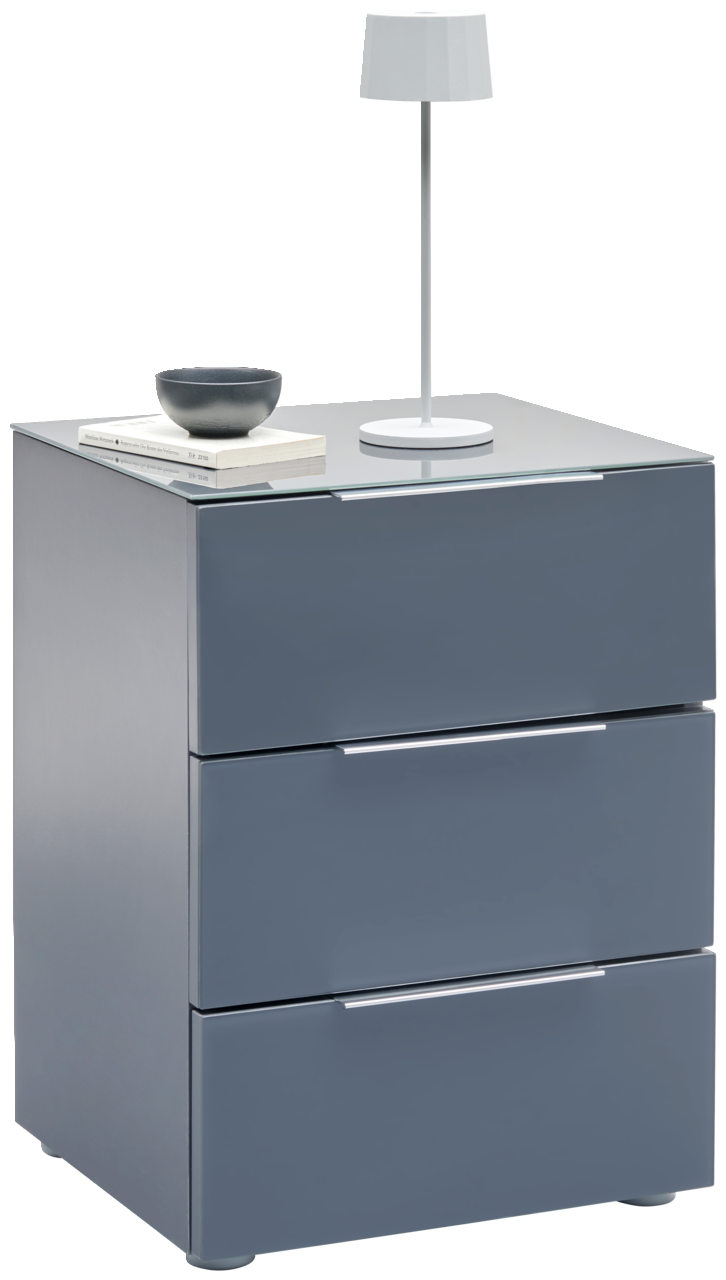 Voleo Nachtkonsole MALIN Moderne Nachtkonsole in Grau mit drei Schubladen, darauf eine weiße Tischlampe und Bücher, seitliche Perspektive