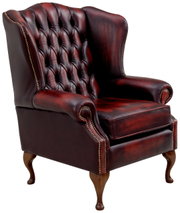 Oorfauteuil van donkerrood leer met knopen en houten poten, zijaanzicht