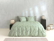 Grüne Bettwäsche mit floralem Muster auf einem Bett, umgeben von modernen Lampen, aus der Frontalperspektive fotografiert.