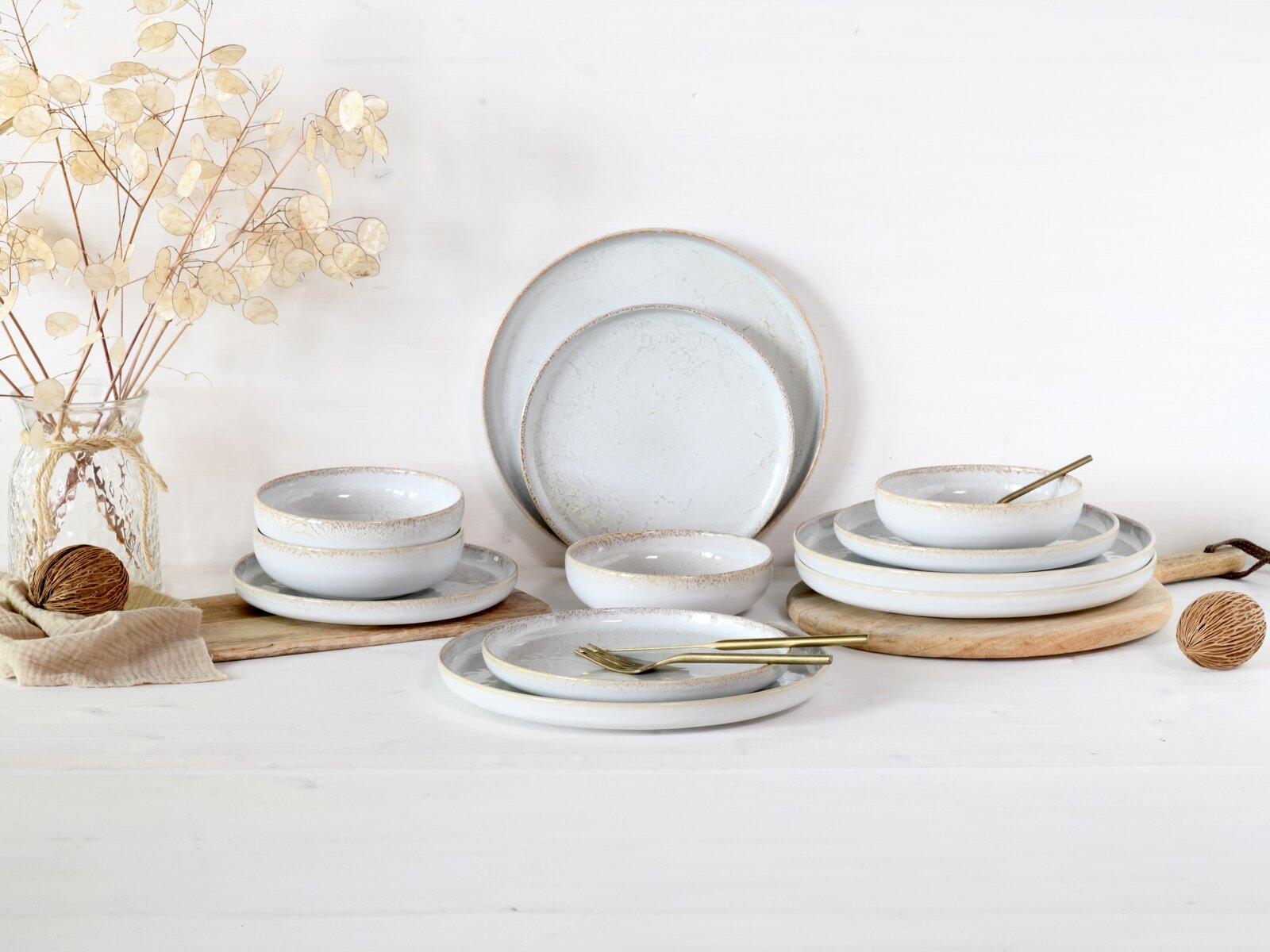 Creatable Tellerset 12-tlg UNO Rustikales Keramik-Geschirrset in Hellgrau mit Speise- und Desserttellern sowie Schalen auf weißem Hintergrund, seitliche Frontansicht mit leicht erhöhtem Blickwinkel