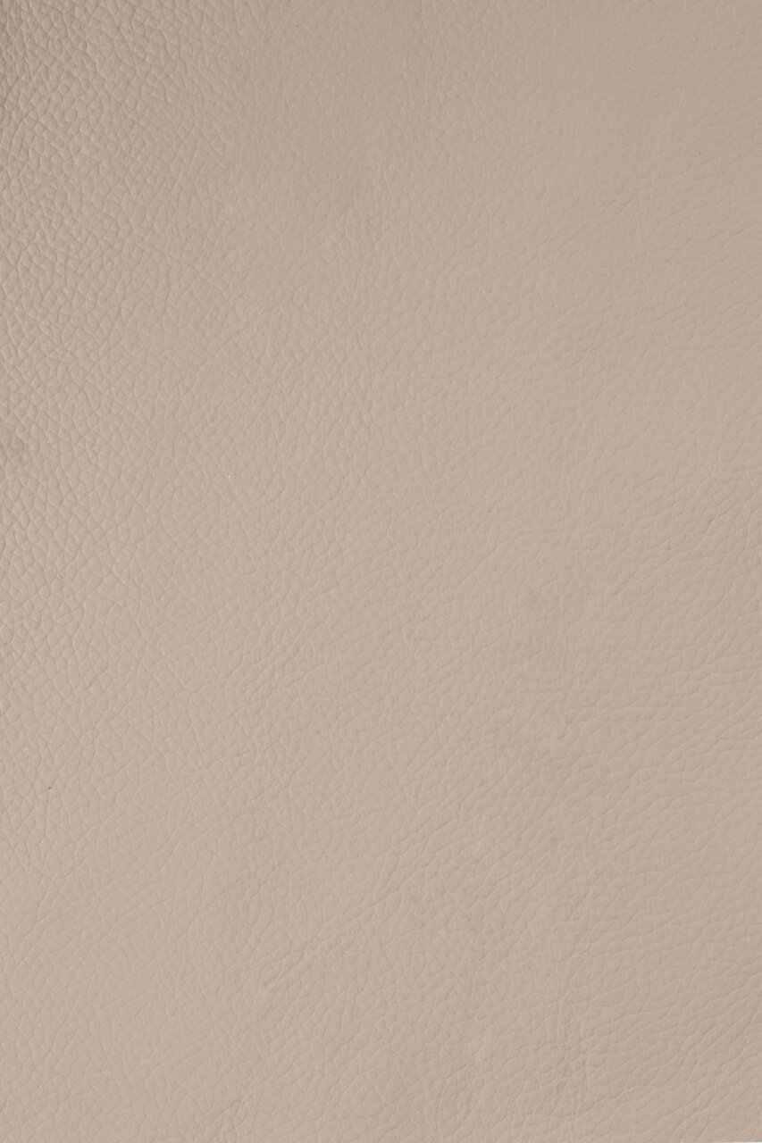 Nahaufnahme einer beigen Lederstruktur, von oben betrachtet.