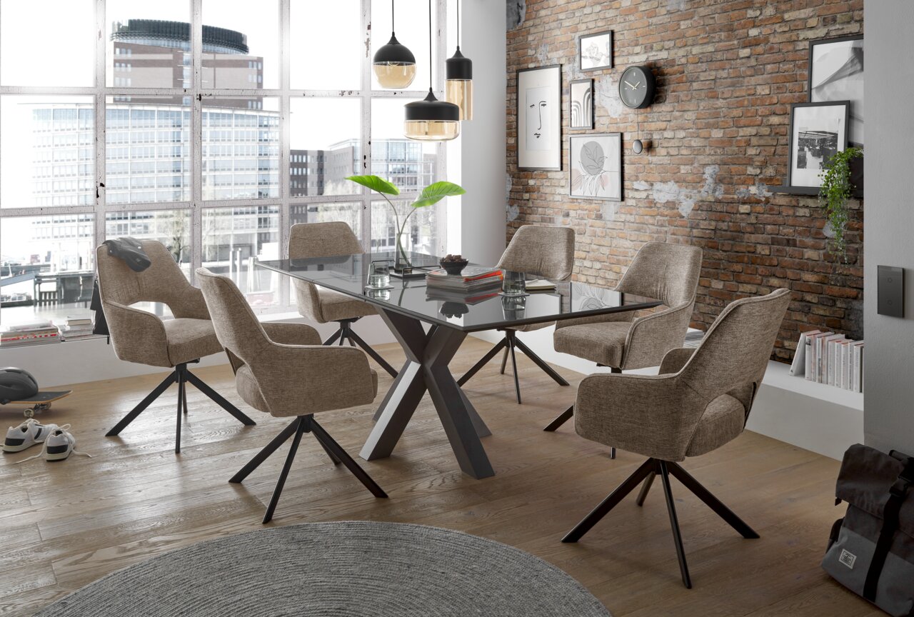 Moderne eethoek met zes beige stoelen met armleuningen rond een rechthoekige glazen tafel, op de achtergrond grote ramen met uitzicht op de stad, perspectief van schuin bovenaf.