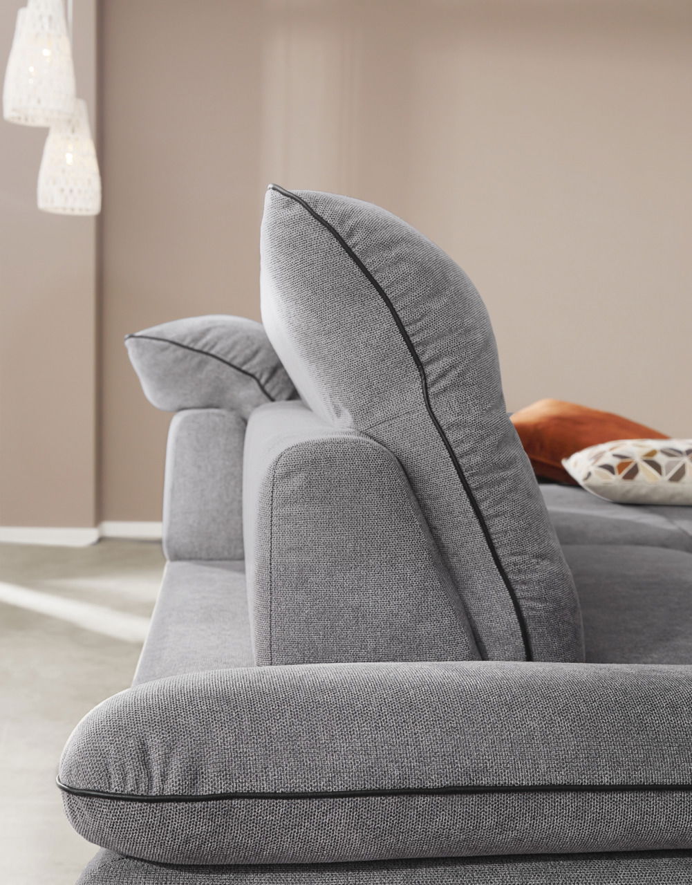 Seitenansicht einer grauen Longchairkombination mit weichen Kissen und eleganter Naht.