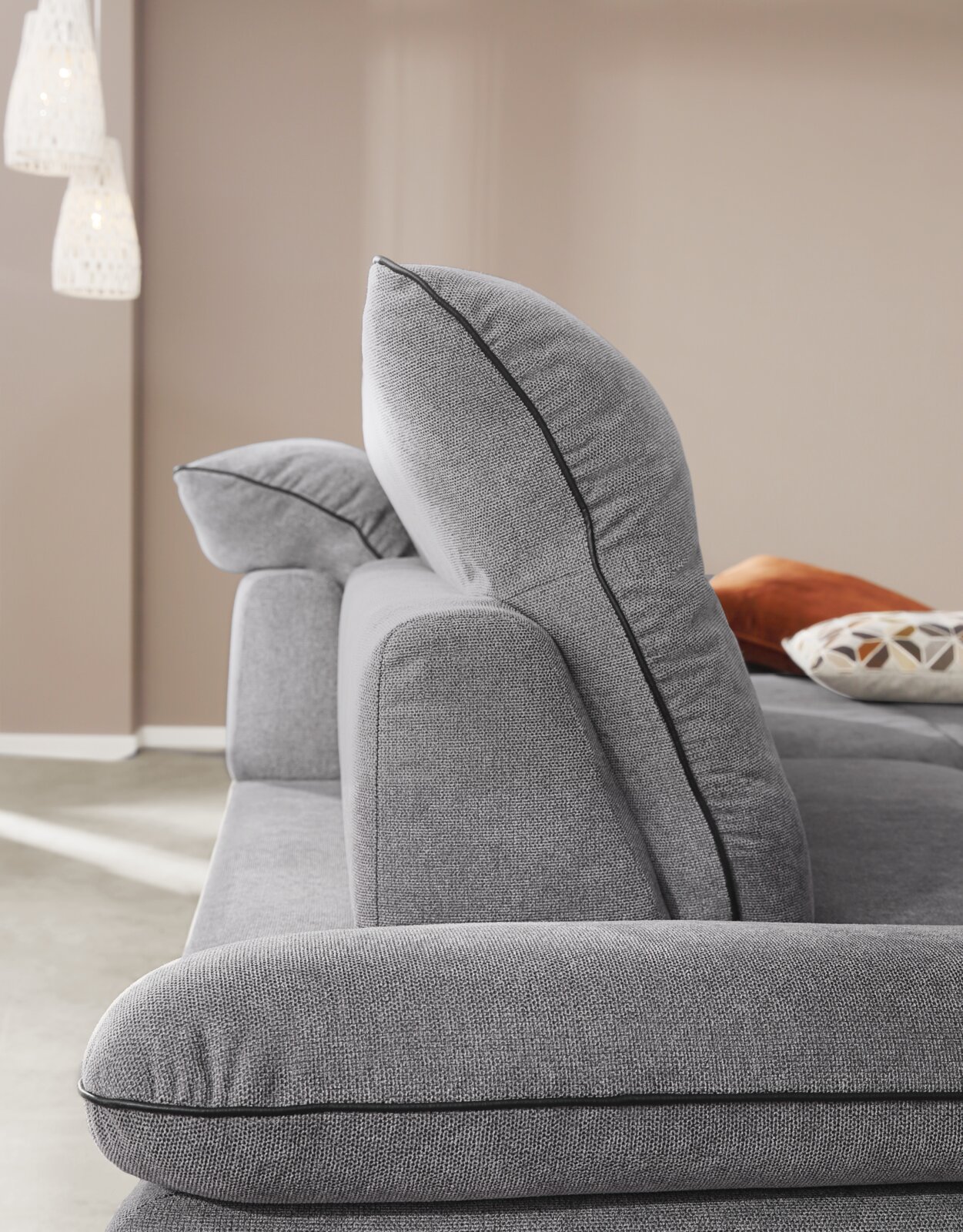 Seitenansicht einer grauen Longchairkombination mit weichen Kissen und eleganter Naht.