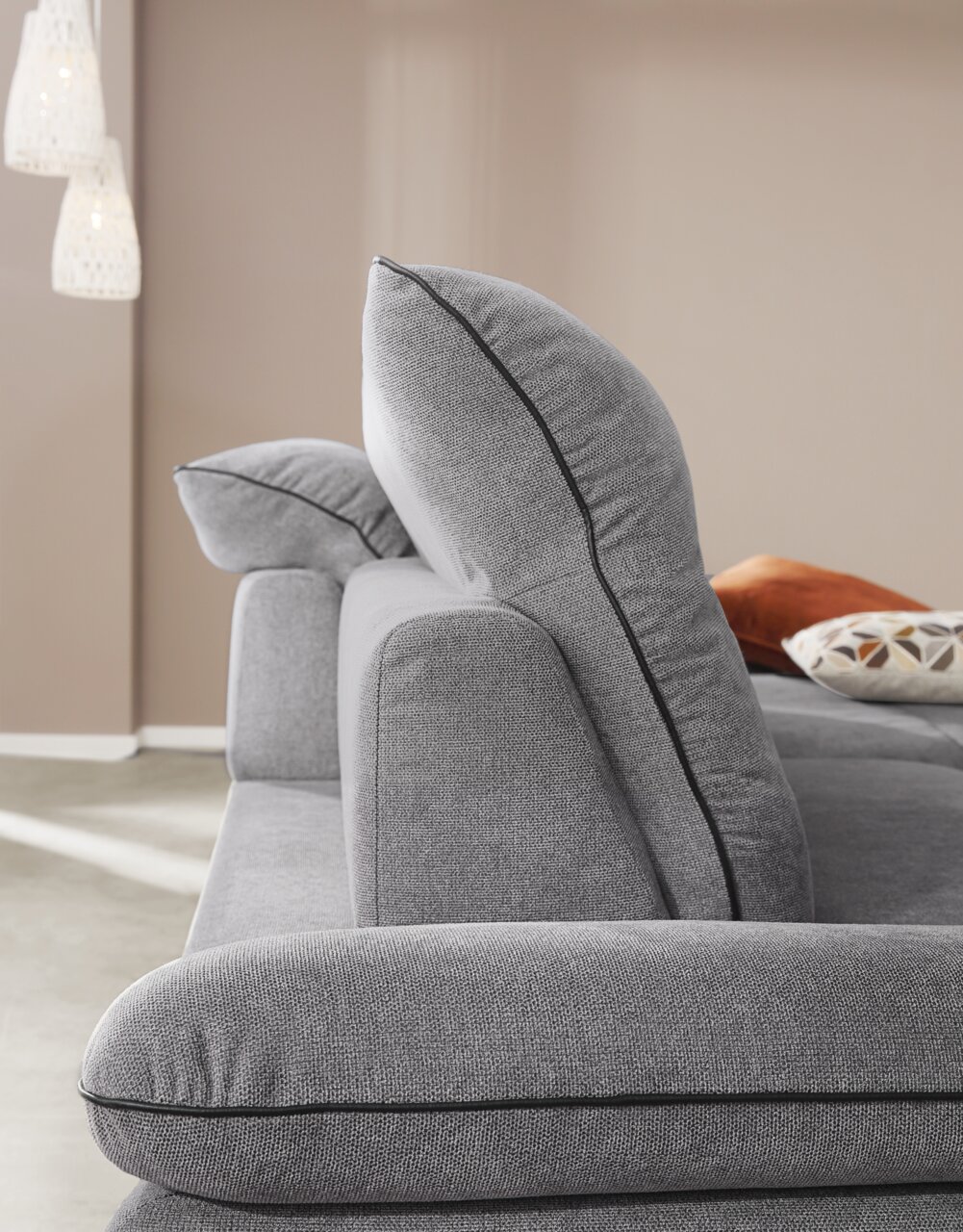 Zijaanzicht van een grijze longchair-set met zachte kussens en elegante stiksels.