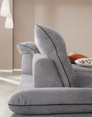 Zijaanzicht van een grijze longchair-set met zachte kussens en elegante stiksels.