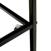 Detailfoto vanuit een schuin zijaanzicht: zwart metalen frame met glazen bodem, glazen blad met doorzichtige afstandhouder