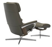 Rückansicht eines modernen Stressless Einzelsessels mit Hocker in grauem Leder und Holzdetails, auf einem Metallfuß.