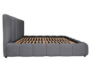 Seitliche Ansicht eines grauen Polsterbettgestells mit hohem Kopfteil und Lattenrost.