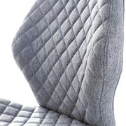 Nahaufnahme eines grauen Drehstuhls mit gestepptem Stoffbezug, seitliche Perspektive.