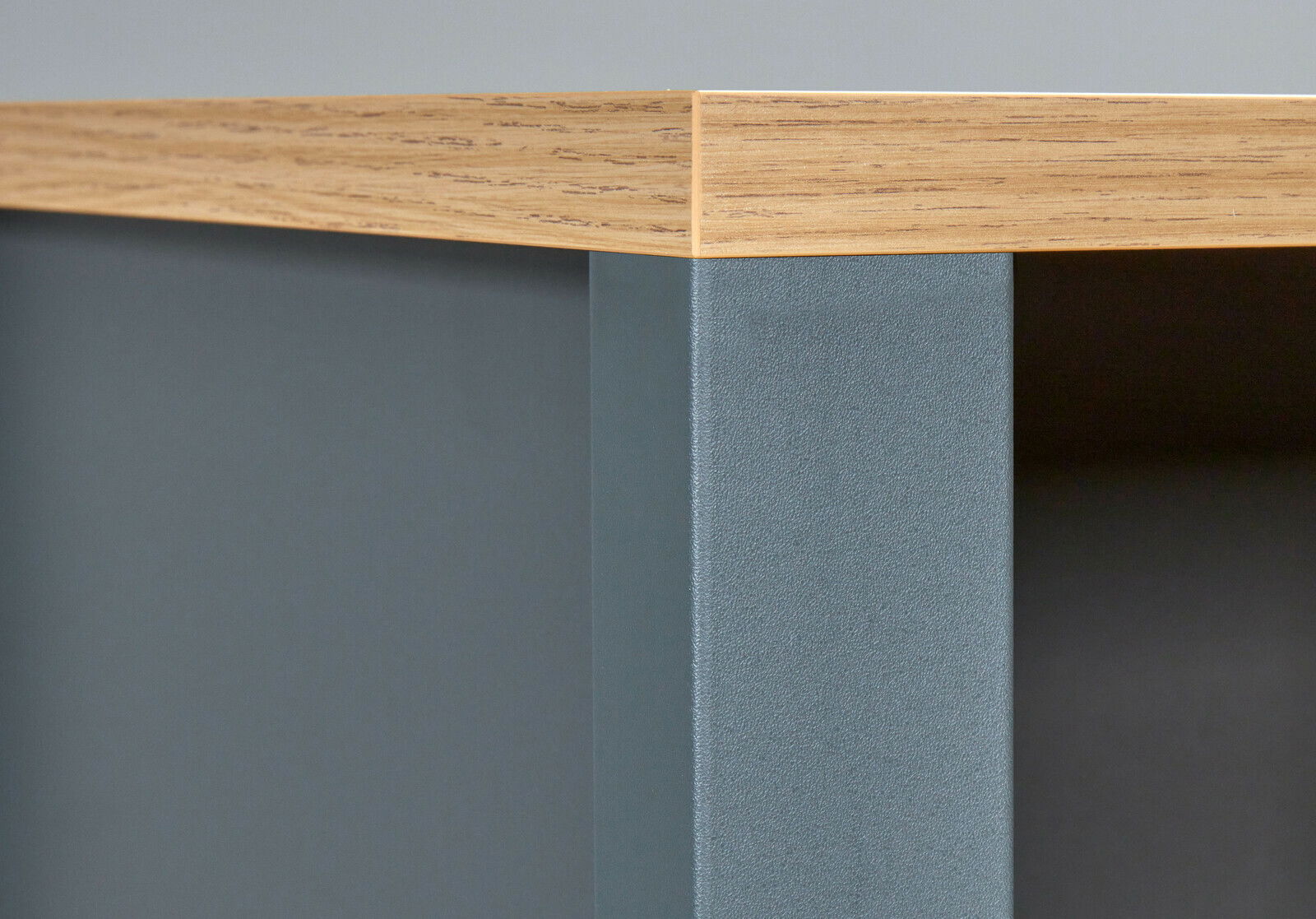 Nahaufnahme einer Ecke eines Standregals mit Holzoberfläche und grauer Seitenwand.