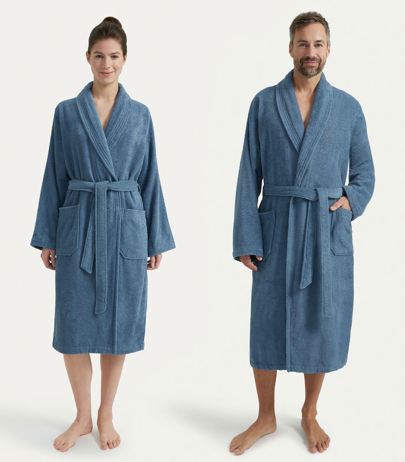 Zwei Personen tragen einen blauen Bademantel mit Schalkragen, frontal fotografiert.