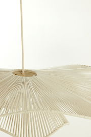 Nahaufnahme einer Hängeleuchte mit einem Schirm aus beigem Stoff, der in Falten gelegt ist. Die Perspektive zeigt die Leuchte von unten.